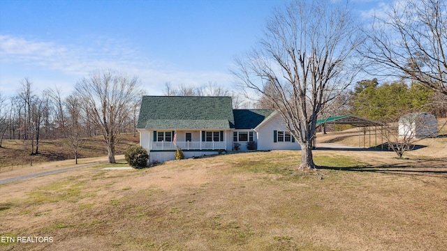 view of front facade featuring driveway, covered porch, a front lawn, and roof with shingles