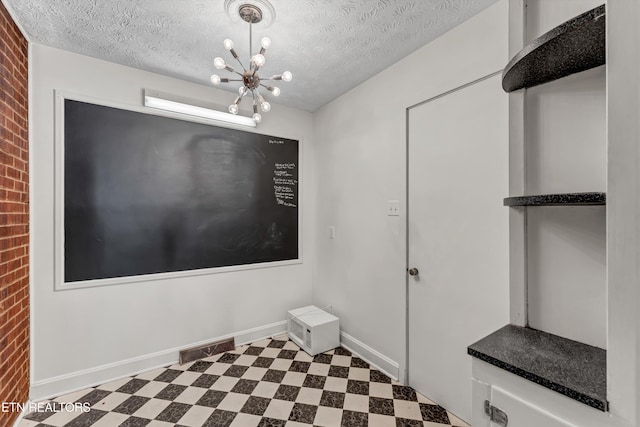 unfurnished dining area with baseboards, a textured ceiling, and tile patterned floors