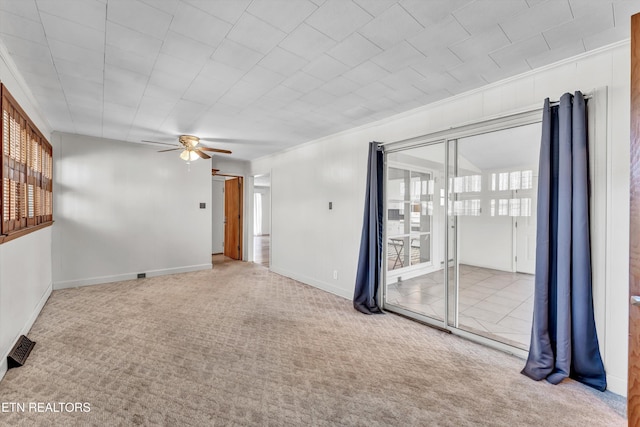 unfurnished room with carpet floors, ceiling fan, visible vents, and baseboards