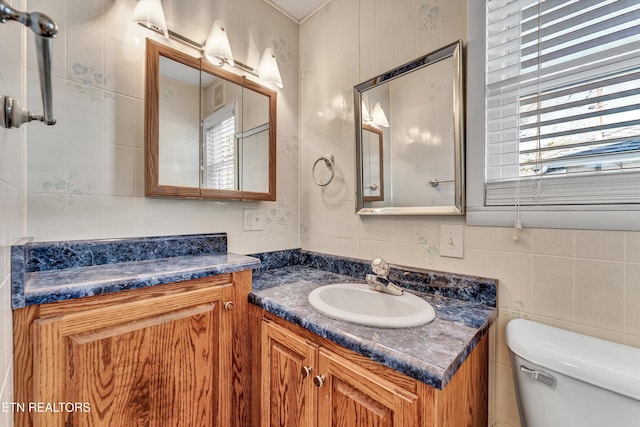 bathroom with tasteful backsplash, toilet, tile walls, and vanity