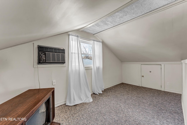 additional living space featuring a wall unit AC, carpet, and vaulted ceiling