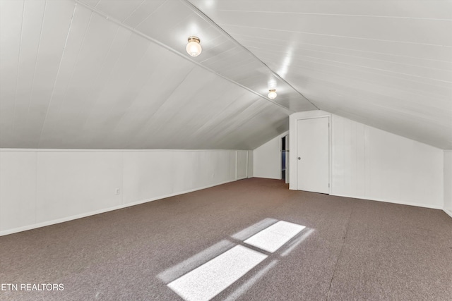 bonus room with carpet flooring and vaulted ceiling