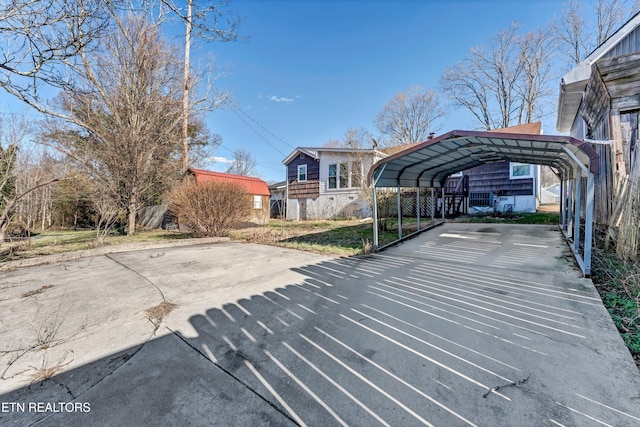 view of car parking with driveway and a detached carport