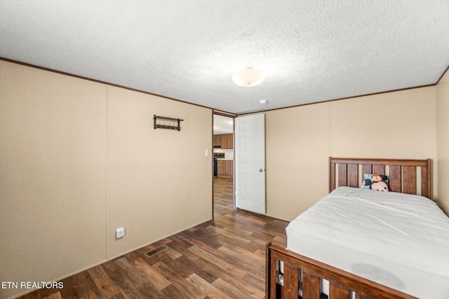 1326 Moss Rd, Philadelphia, TN 37846 - bedroom featuring a textured ceiling, dark wood-type flooring, visible vents, and ornamental molding