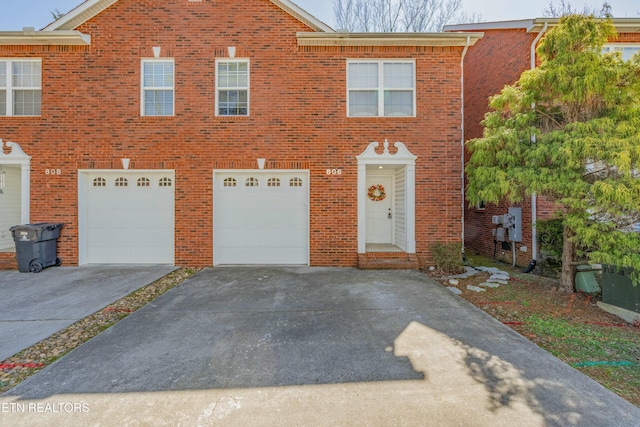 view of front of house with a garage, driveway, and brick siding