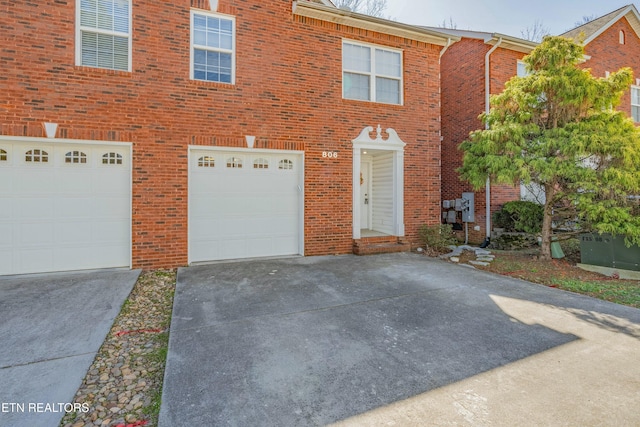 view of front of property with driveway, an attached garage, and brick siding