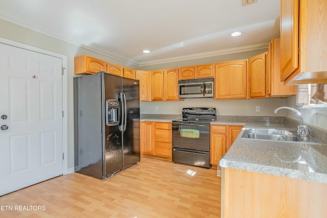 kitchen with crown molding, a sink, light wood-style flooring, and black appliances