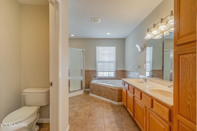 bathroom with a stall shower, a sink, toilet, and tile patterned floors