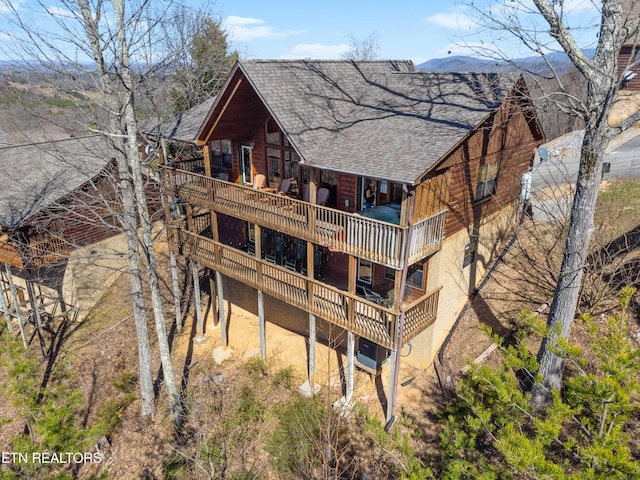 back of house with a shingled roof, a deck, and central AC unit