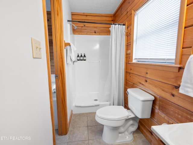 full bathroom featuring toilet, a shower with curtain, tile patterned flooring, and wood walls