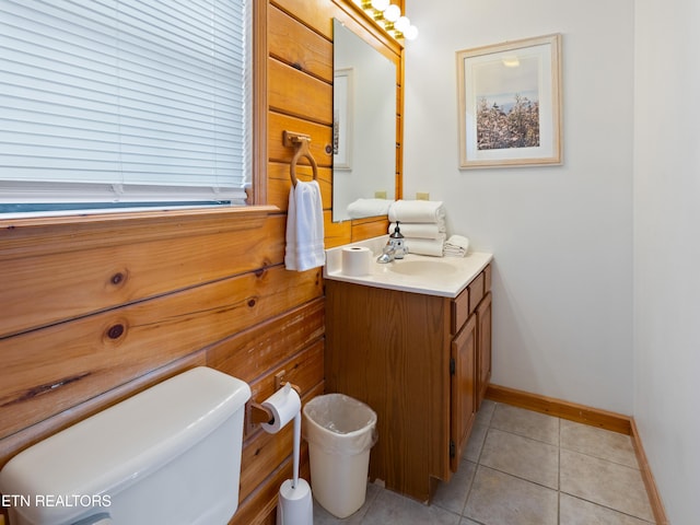 half bathroom featuring baseboards, vanity, toilet, and tile patterned floors