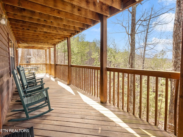 wooden deck featuring a forest view