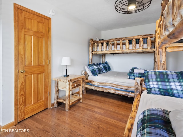 bedroom featuring baseboards and wood finished floors