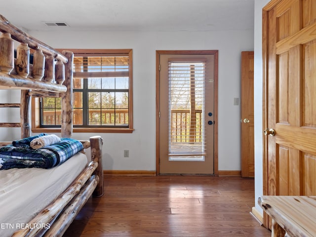 bedroom with visible vents, baseboards, and wood finished floors