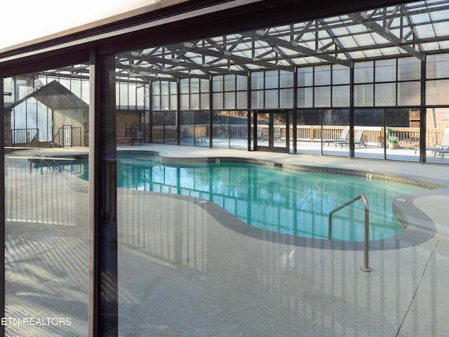 community pool featuring a patio area and glass enclosure