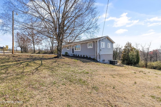 view of side of home with a yard and central AC unit