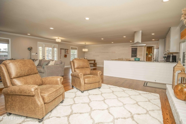 living area featuring recessed lighting, crown molding, and wood finished floors