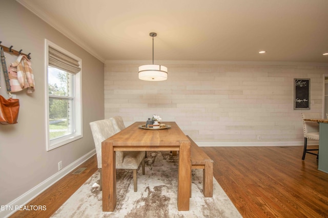 dining space with visible vents, crown molding, baseboards, and wood finished floors