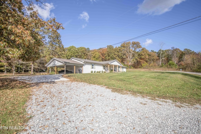 single story home featuring a carport, a front lawn, and driveway