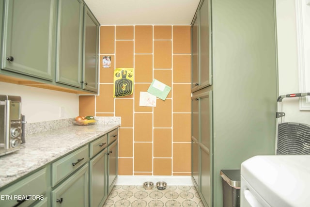 clothes washing area featuring cabinet space and light tile patterned flooring