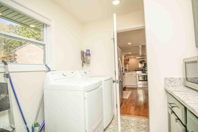 laundry room featuring light wood-style flooring, washer and clothes dryer, cabinet space, and recessed lighting