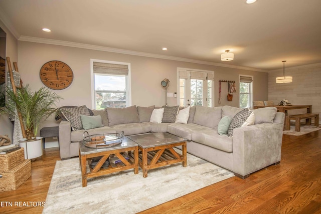 living area with plenty of natural light, crown molding, wood finished floors, and recessed lighting