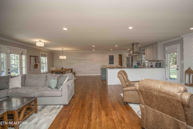 living area with dark wood-style flooring, recessed lighting, and crown molding