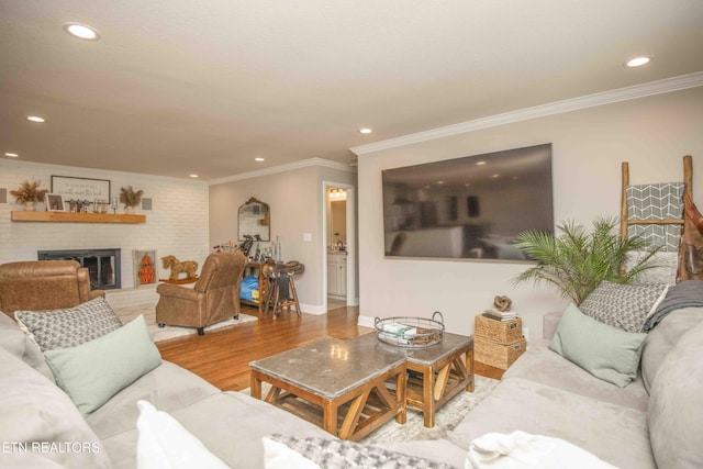 living room featuring a brick fireplace, wood finished floors, and recessed lighting