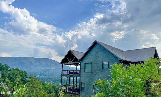 view of property exterior with metal roof and a mountain view