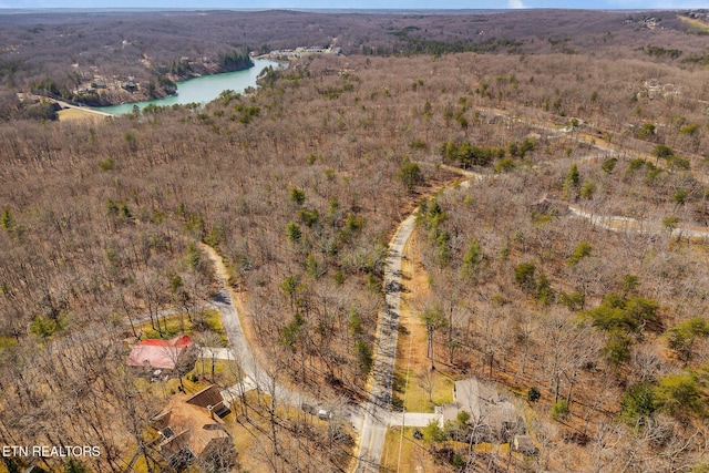 aerial view featuring a forest view and a water view