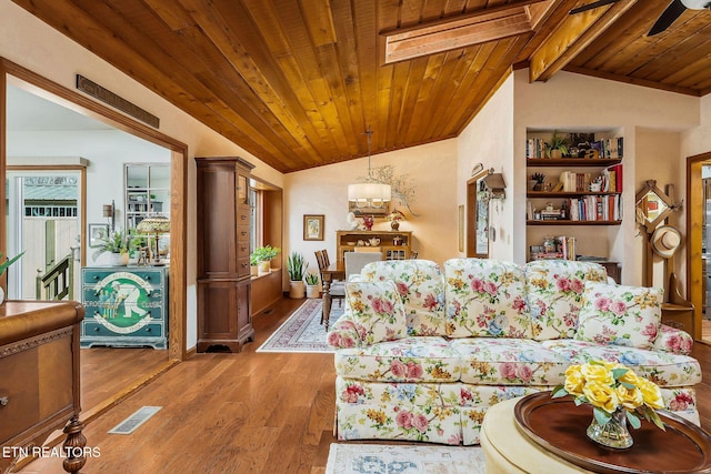 living area featuring vaulted ceiling with beams, wooden ceiling, visible vents, and wood finished floors