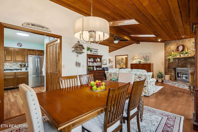 dining room featuring wood ceiling, light wood-style flooring, and lofted ceiling with beams