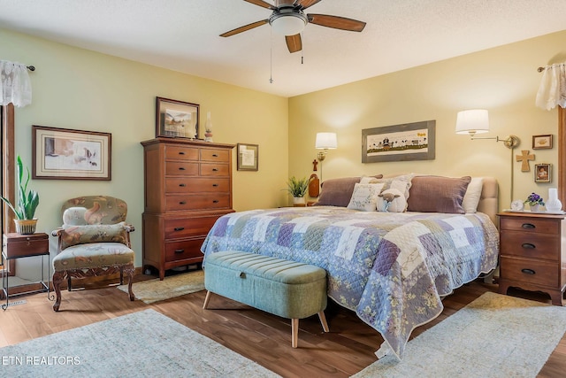 bedroom featuring a textured ceiling, wood finished floors, and a ceiling fan