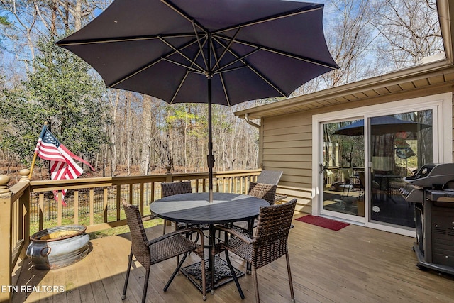 wooden terrace featuring grilling area and outdoor dining space