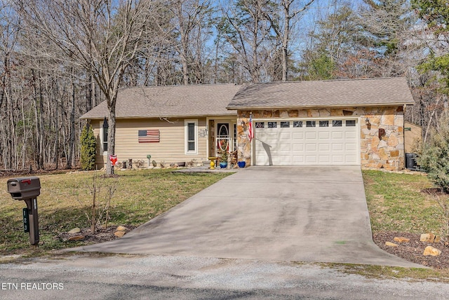 single story home with a garage, stone siding, driveway, and a front lawn