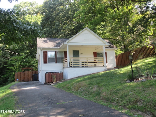 bungalow featuring fence, a porch, and a front yard