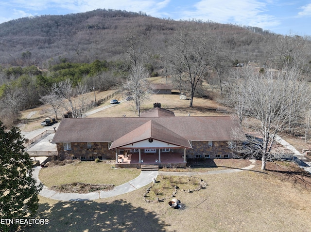 drone / aerial view with a wooded view and a mountain view