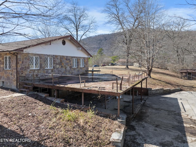 exterior space with a deck and stone siding