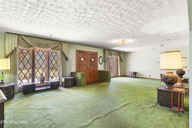 living area with a textured ceiling, carpet, and baseboards