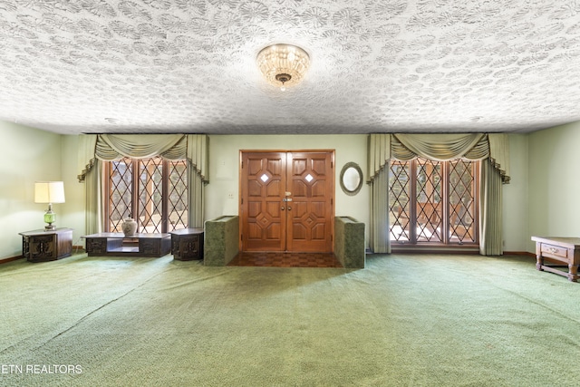 carpeted entryway with baseboards and a textured ceiling