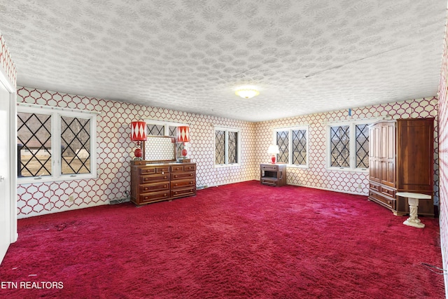 unfurnished room featuring a textured ceiling and wallpapered walls