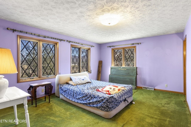 carpeted bedroom featuring baseboards, visible vents, and a textured ceiling