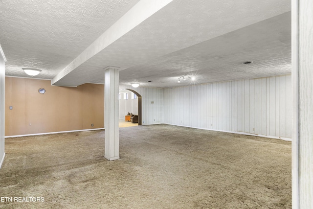 finished basement featuring a textured ceiling and carpet flooring