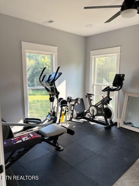 workout area featuring a ceiling fan, visible vents, and a healthy amount of sunlight