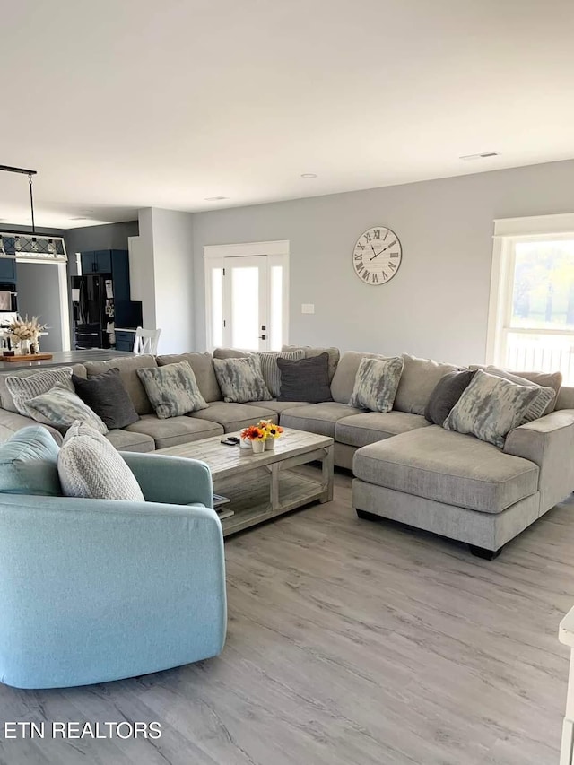 living room featuring visible vents and wood finished floors