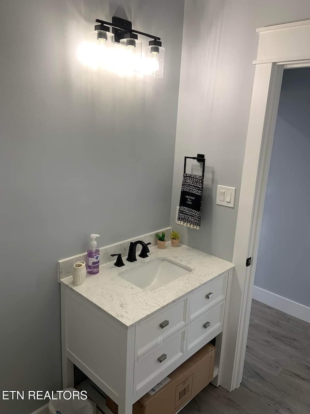 bathroom with vanity, baseboards, and wood finished floors