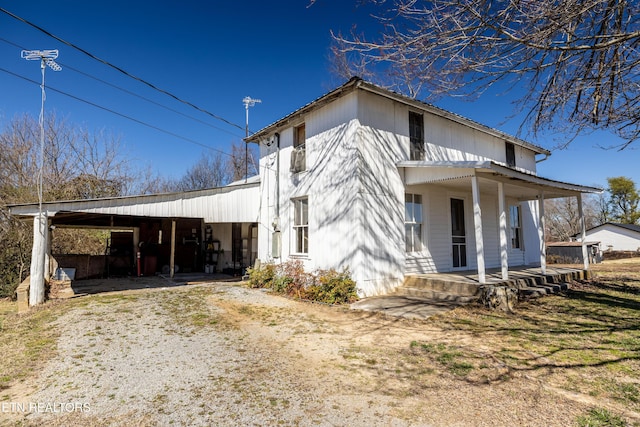 view of front of property featuring a carport, covered porch, and driveway