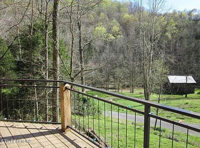 balcony featuring a rural view and a wooded view