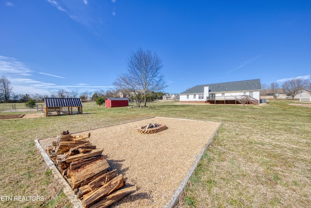 view of yard with a storage unit, an outdoor fire pit, and an outdoor structure