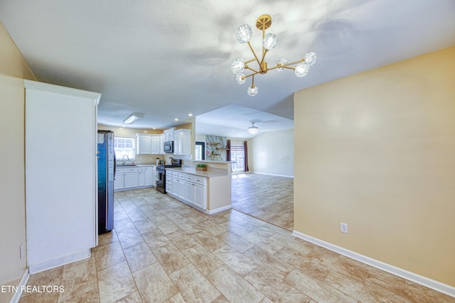 kitchen featuring a chandelier, a sink, white cabinetry, light countertops, and appliances with stainless steel finishes